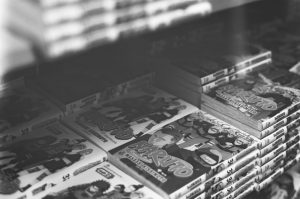Stacks of manga books on a shelf representing 2026 best-selling manga